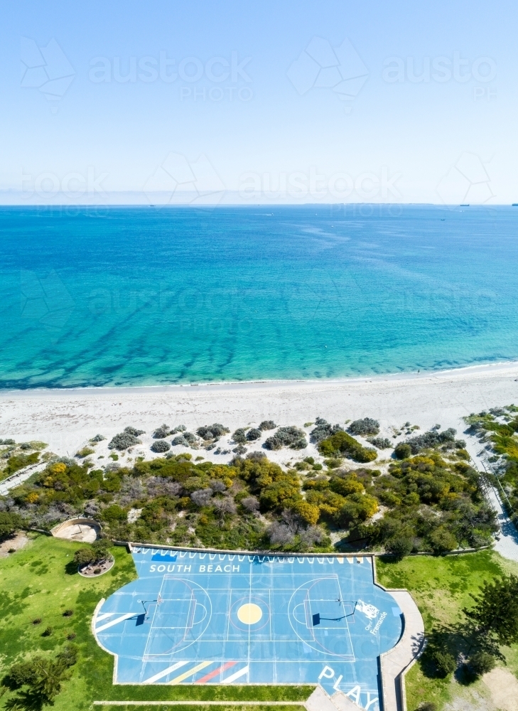 Aerial view of beachside basketball court and ocean. - Australian Stock Image