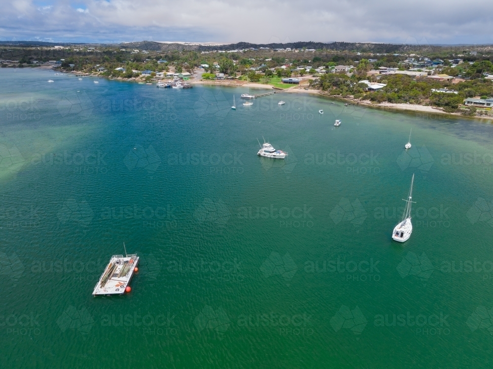 Image of Aerial view of boats and yachts anchored a calm shallow bay ...