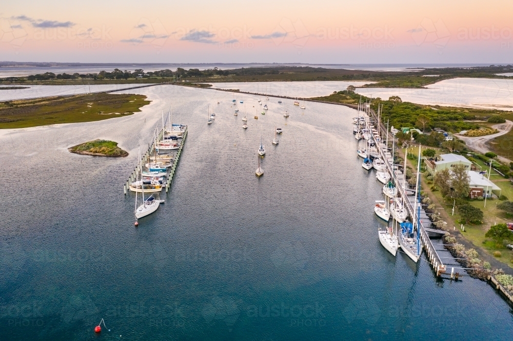 Aerial view of boats and yachts anchored along jettys at a marina - Australian Stock Image