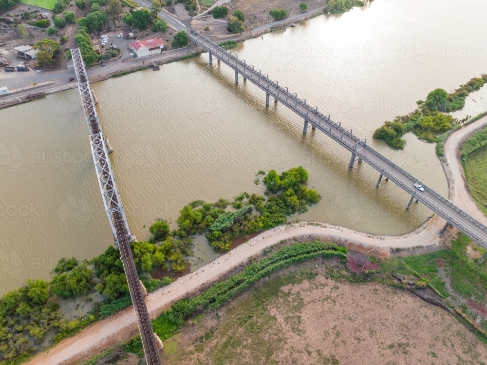 Aerial view of bridges crossing a wide brown river - Australian Stock Image