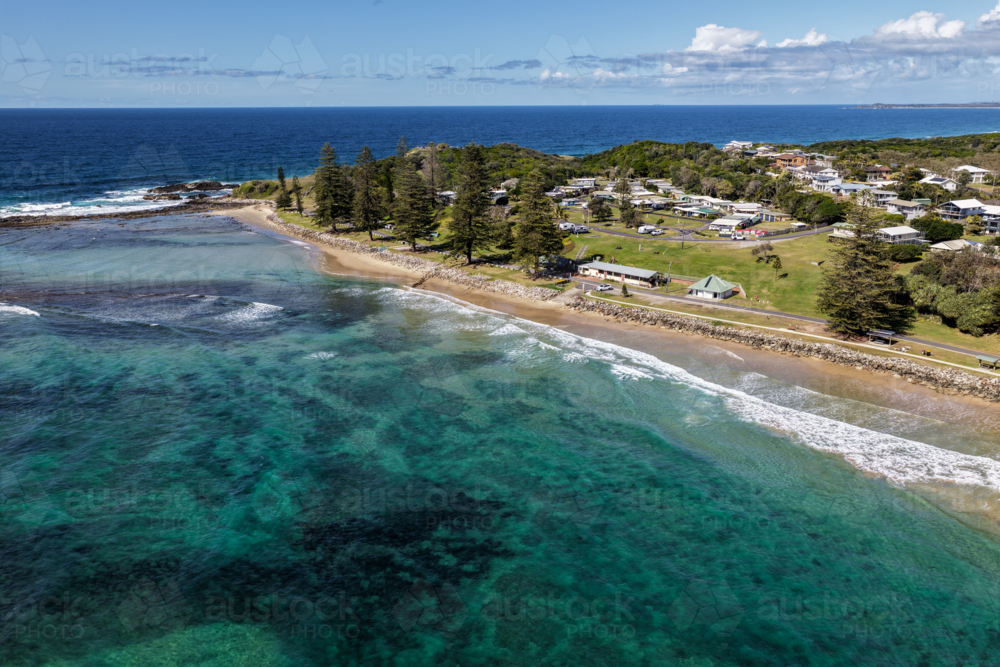 Aerial view of Brooms Head Beach and rocky headland, showing the sandy shoreline, Pacific Ocean - Australian Stock Image
