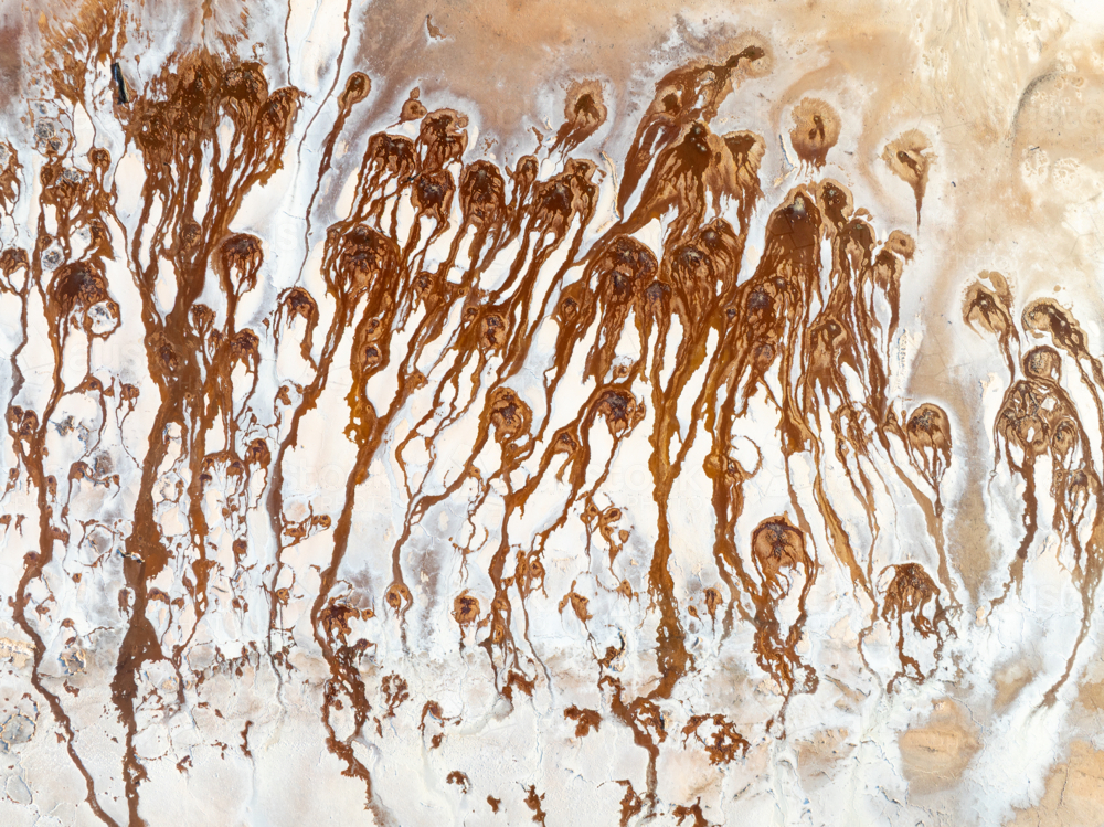 Aerial view of brown groundwater making patterns in a salt lake - Australian Stock Image