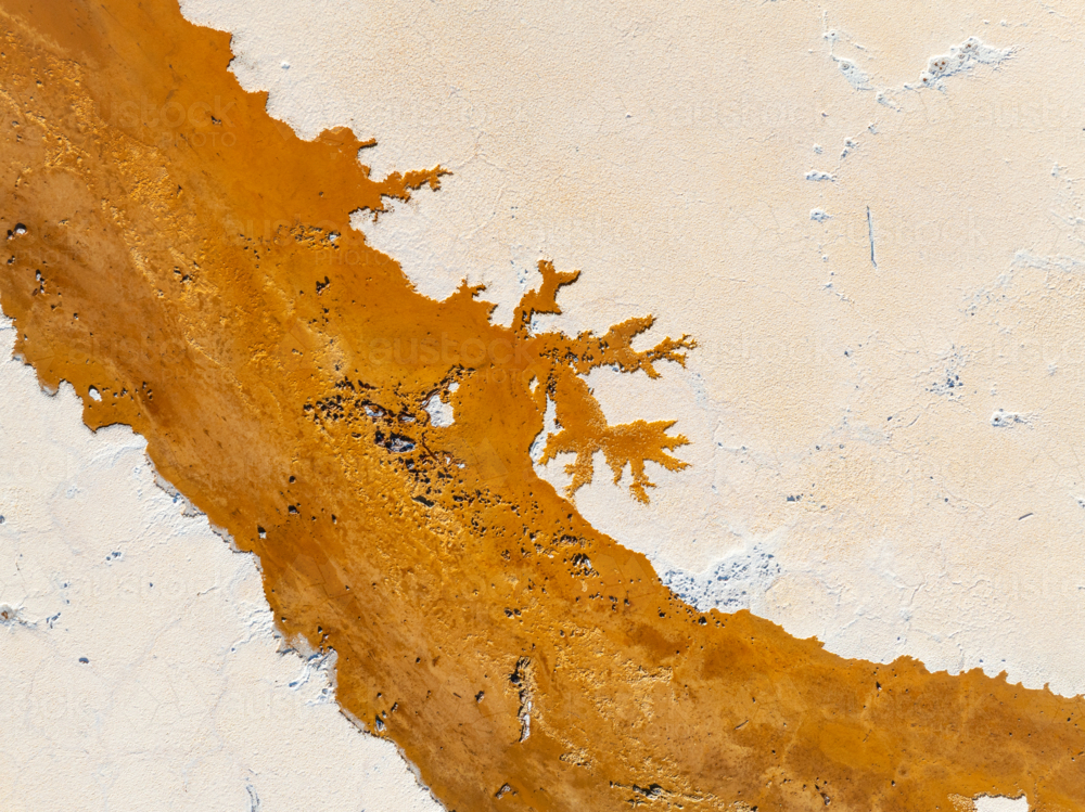 Aerial view of brown groundwater making patterns in a salt lake - Australian Stock Image