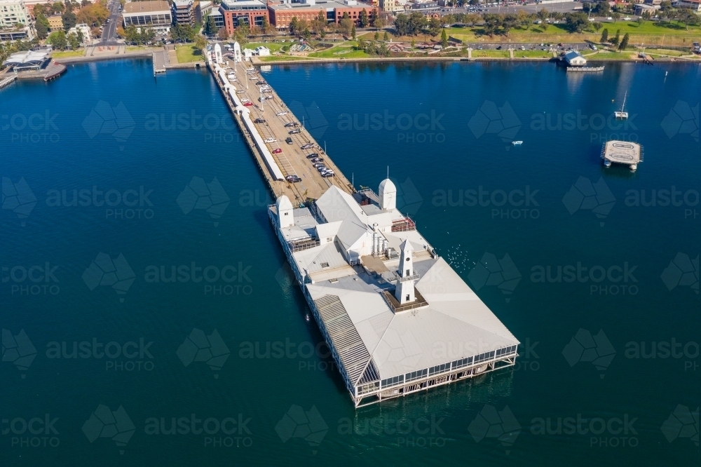 Aerial view of buildings on the end of a long jetty out over a coastal bay - Australian Stock Image