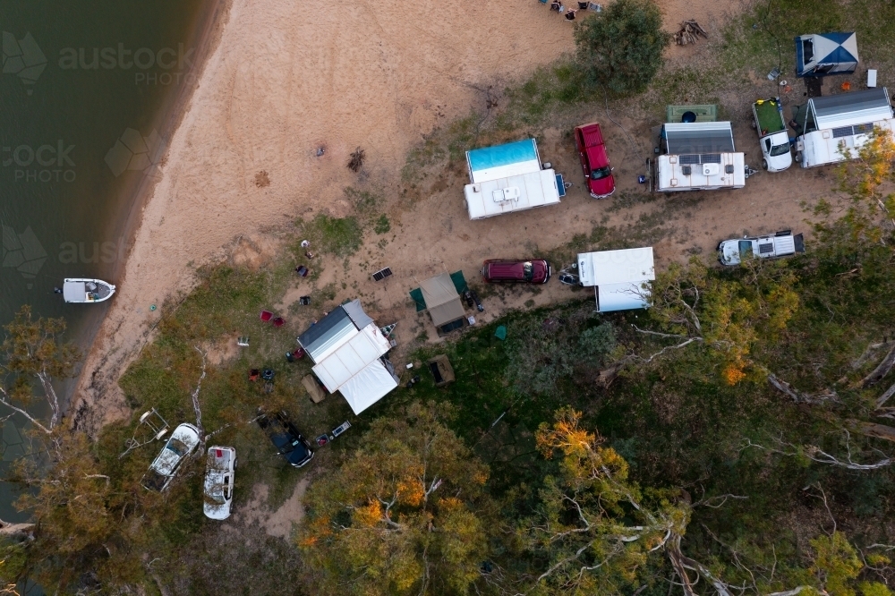 Image of Aerial view of caravans camped under gum trees on the banks of