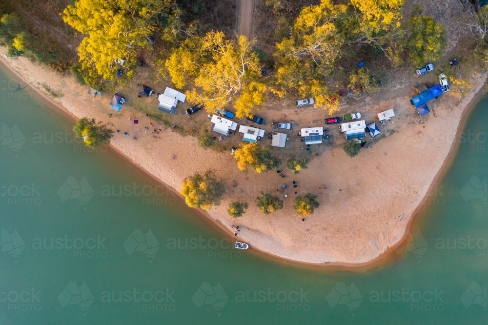 Aerial view of caravans camping near a beach on a river bank - Australian Stock Image