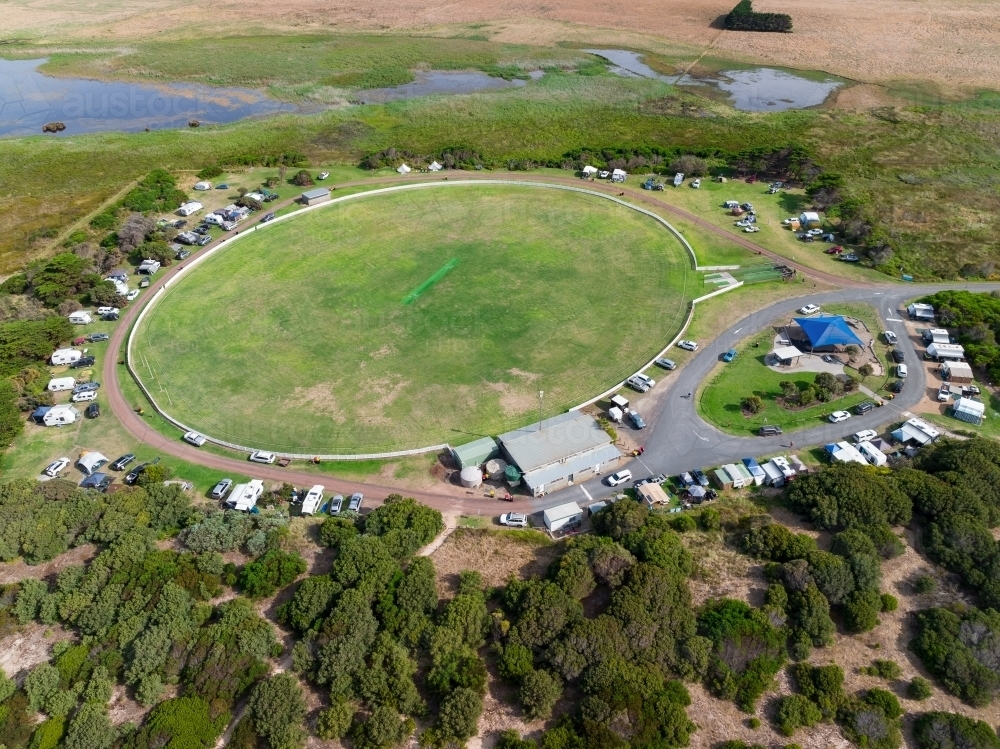 Aerial view of caravans parked around a sporting oval in a rural setting - Australian Stock Image