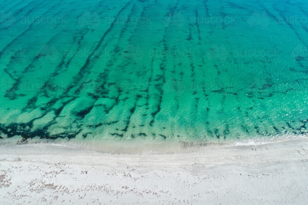 Aerial view of clear water, seafloor patterns, and sandy shore. - Australian Stock Image