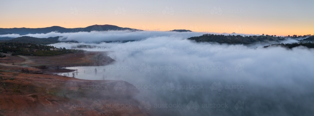 Image of Aerial view of clouds of fog over an inland lake and ...