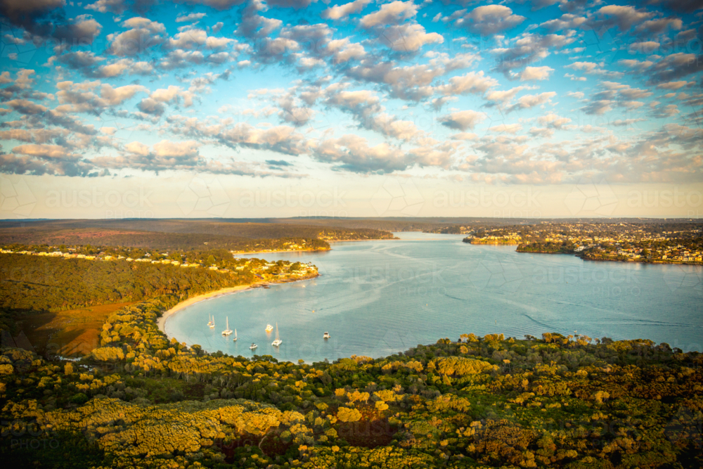 Aerial view of coastal bay with sailboats, houses, and sunset glow over Port Hacking and Bundeena. - Australian Stock Image