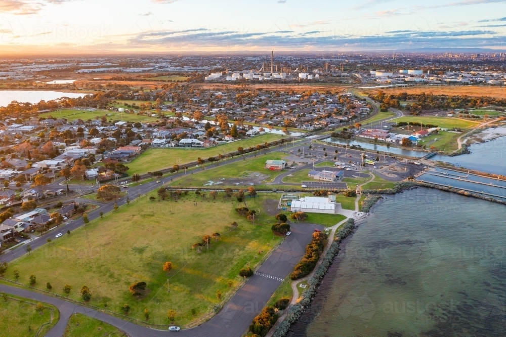 Aerial view of coastal reserve and parkland next to a calm bay at sunset - Australian Stock Image