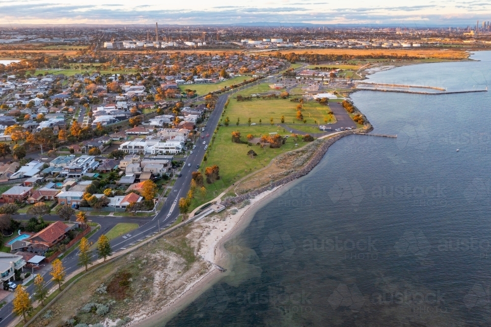 Aerial view of coastal reserve and suburb next to a calm bay - Australian Stock Image