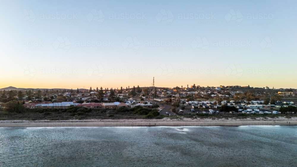 Aerial view of coastal town and caravan park at sunset - Australian Stock Image