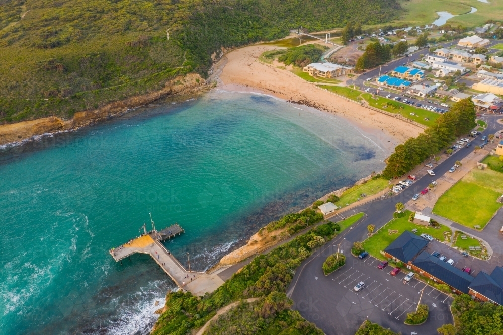Aerial view of coastal town and jetty around a sheltered inlet and beach - Australian Stock Image