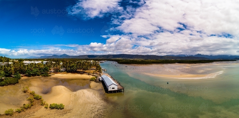 Image of Aerial view of coastline and inlet with wharf and building ...
