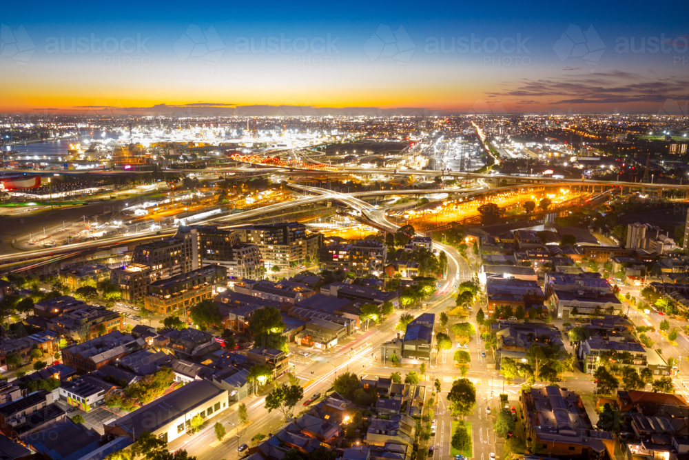 Aerial view of coloured lighting on freeways and suburban streets in a major city at twilight - Australian Stock Image