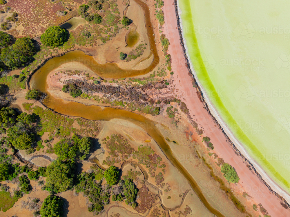 Aerial view of colourful salt evaporation pond and levee banks at a coastal salt farm - Australian Stock Image