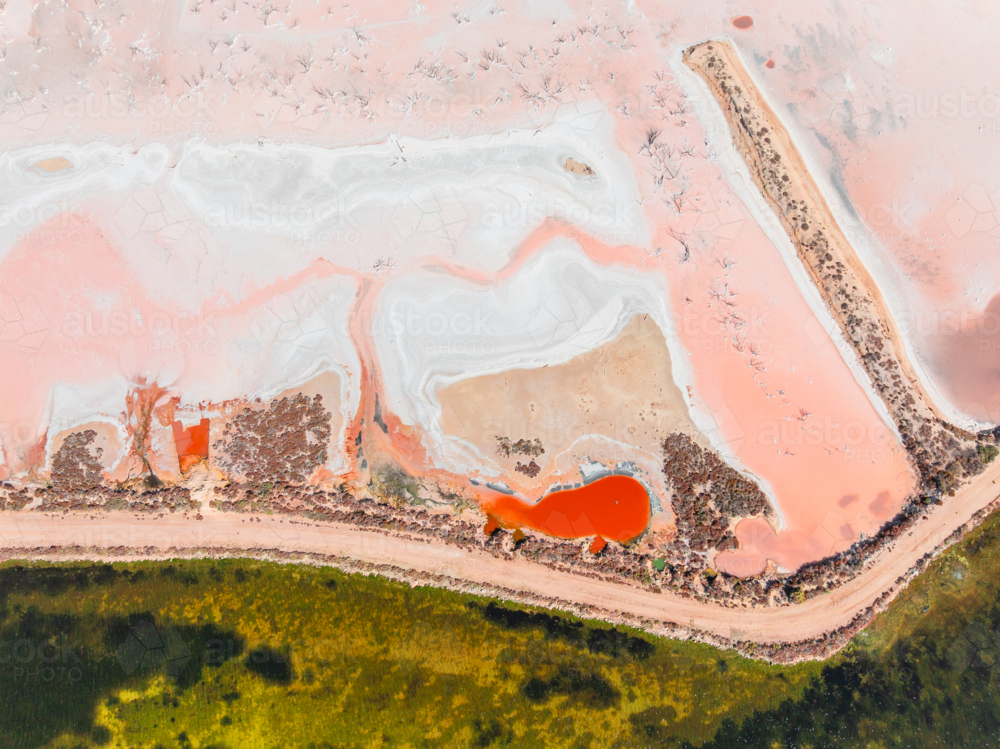 Aerial view of colourful salt evaporation pond and levee banks at a coastal salt farm - Australian Stock Image