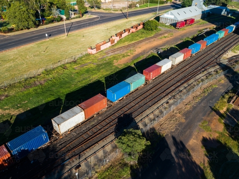 Aerial view of containers on a freight train in small Aussie town - Australian Stock Image