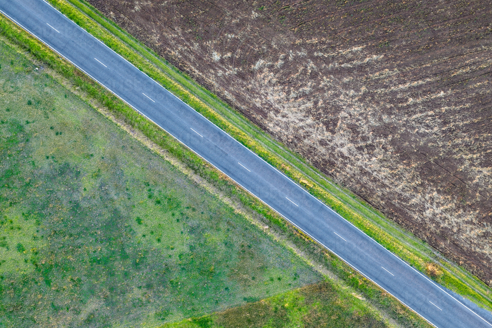 Aerial view of country road passing through agricultural fields. Scenic rural landscape. - Australian Stock Image
