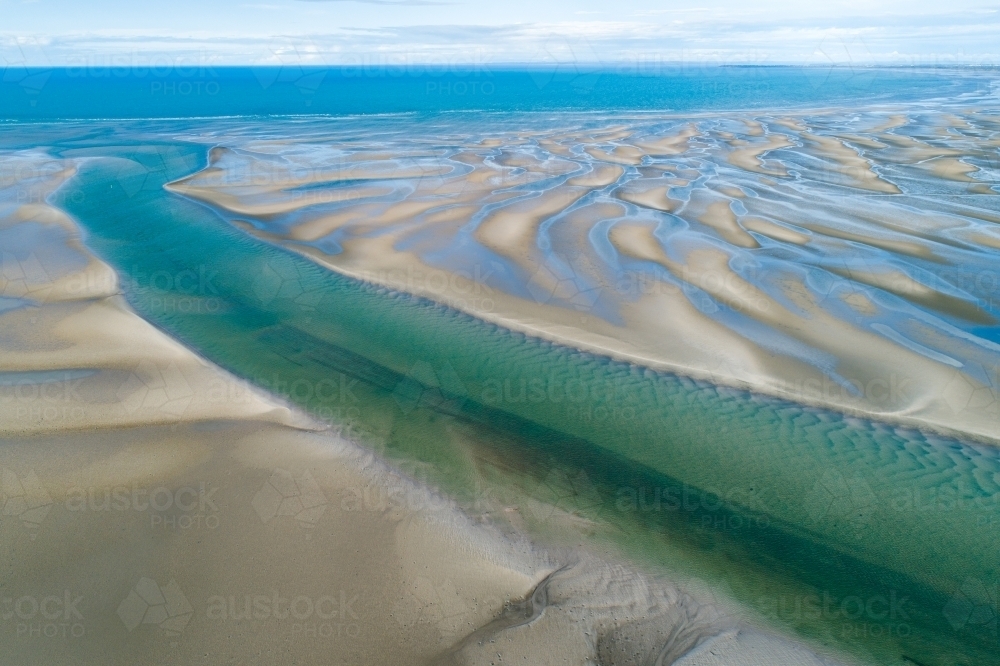 Image of Aerial view of creek and sandbar patterns in shallow blue ...