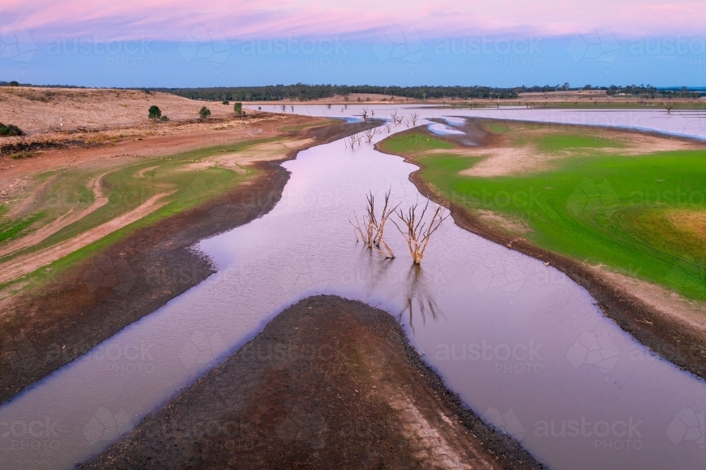 Aerial view of creeks and rivers flowing into a drying reservoir. - Australian Stock Image