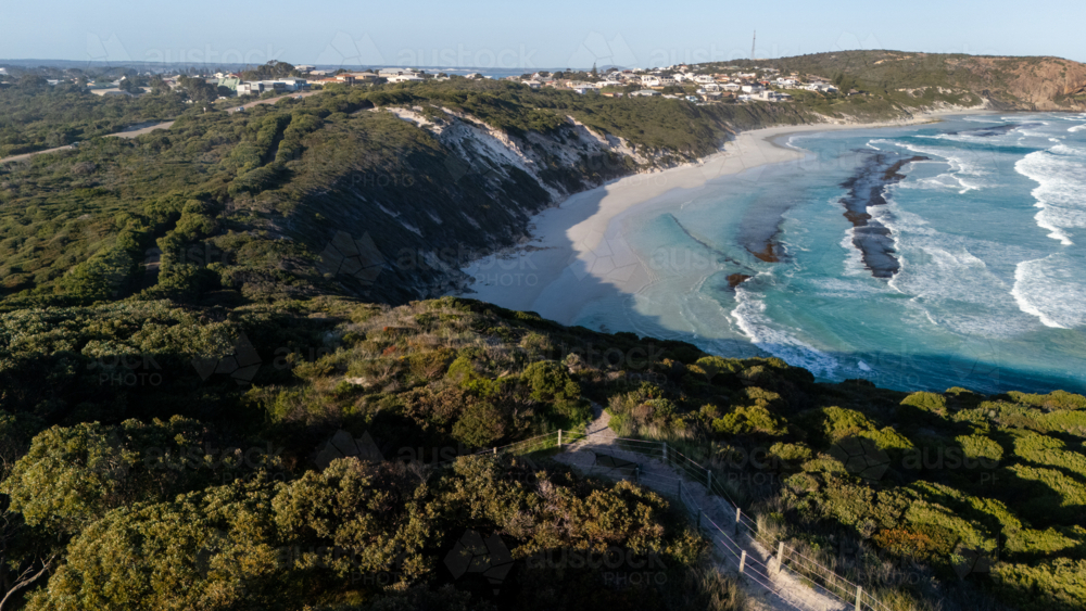 Aerial view of crescent-shaped beach with turquoise water - Australian Stock Image