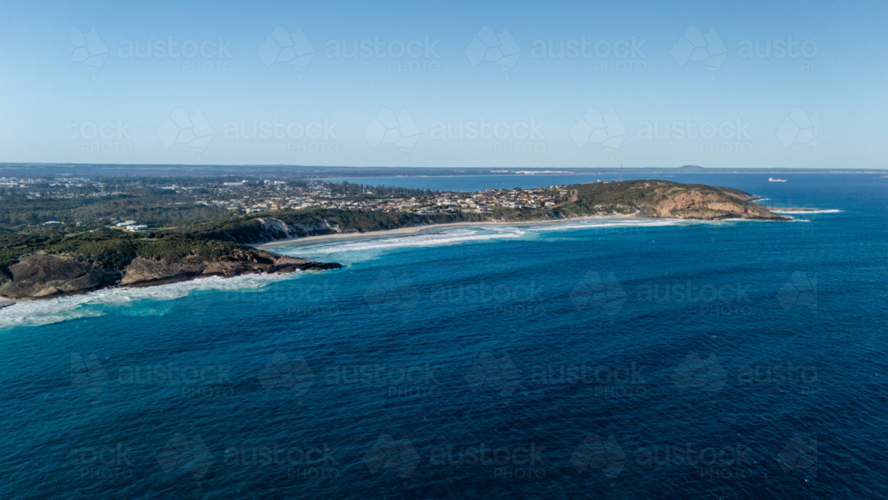Aerial view of crescent-shaped beach with turquoise water - Australian Stock Image