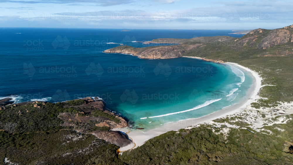 Aerial view of crescent-shaped beach with turquoise water. - Australian Stock Image