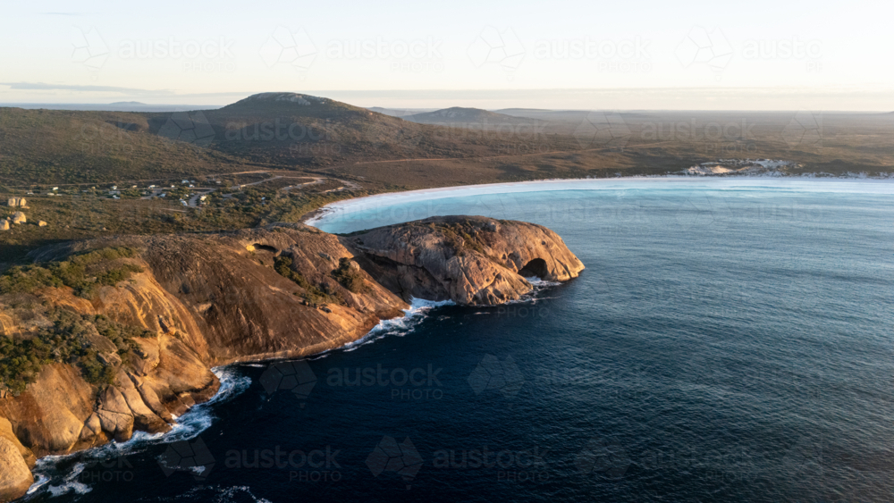 Aerial view of crescent-shaped beach with turquoise water - Australian Stock Image