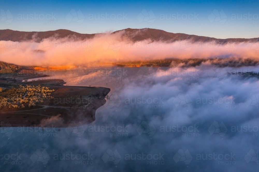 Image of Aerial view of early morning light over a mountain lake ...