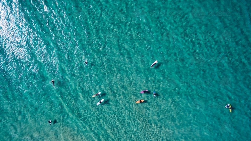 Aerial view of eleven surfers waiting for waves. - Australian Stock Image