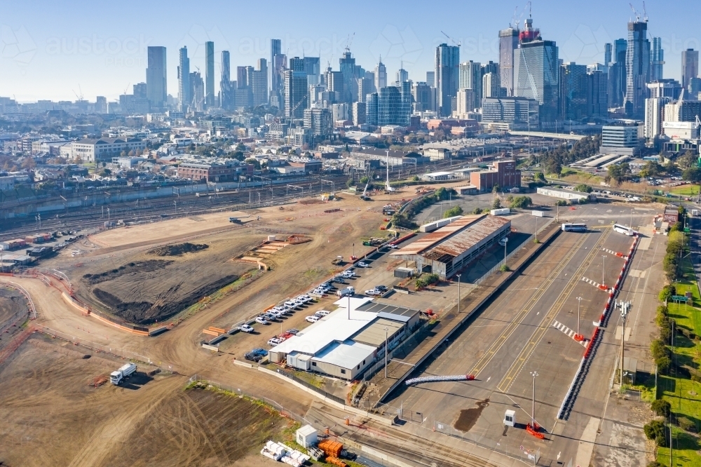 Aerial view of factories and vacant land in front of high rise buildings of a city - Australian Stock Image