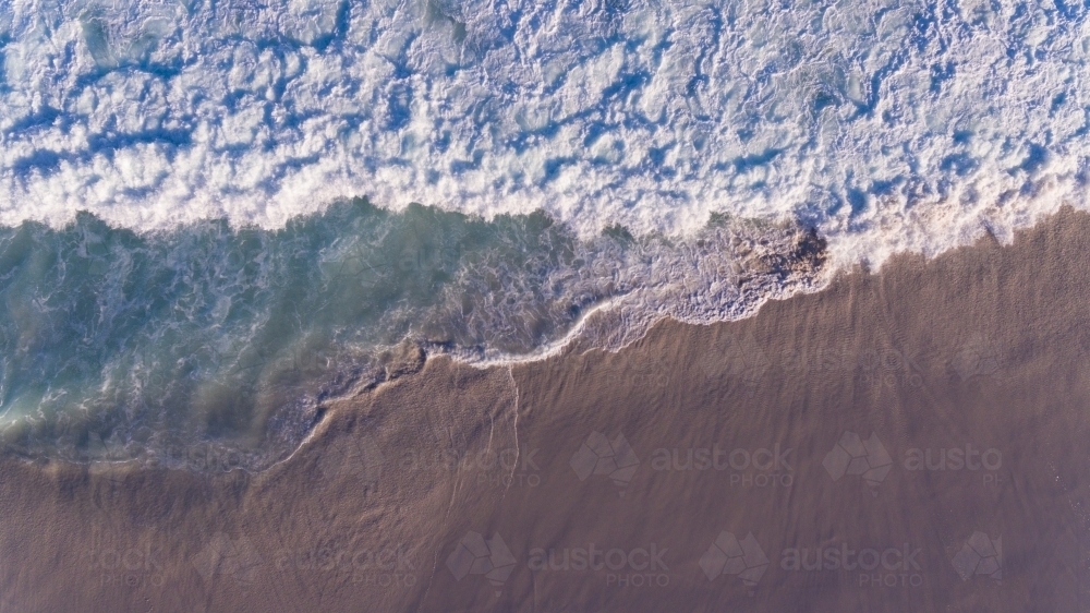 Aerial view of foaming waves  on the seashore - Australian Stock Image
