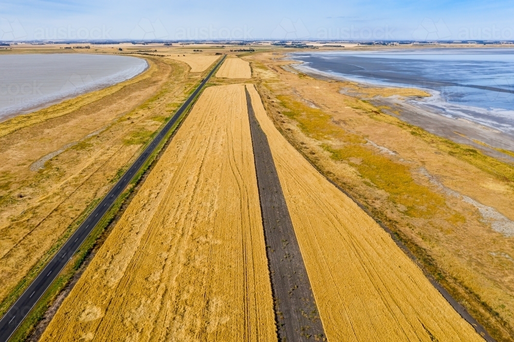 Aerial view of grain crops on a narrow piece of farmland between two salt lakes - Australian Stock Image