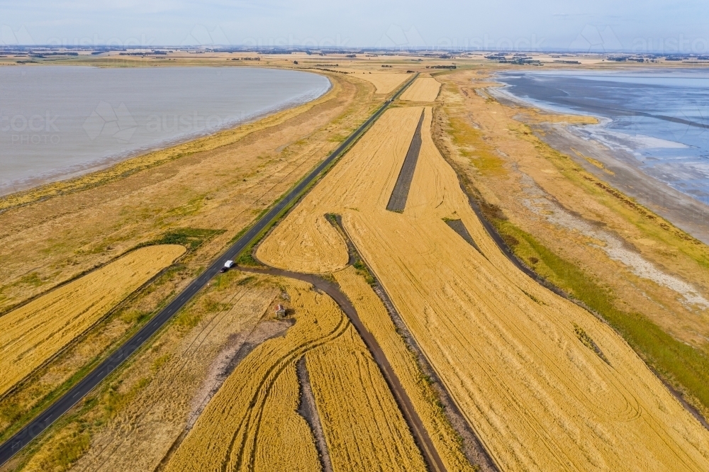 Aerial view of grain crops on a narrow piece of farmland between two salt lakes - Australian Stock Image