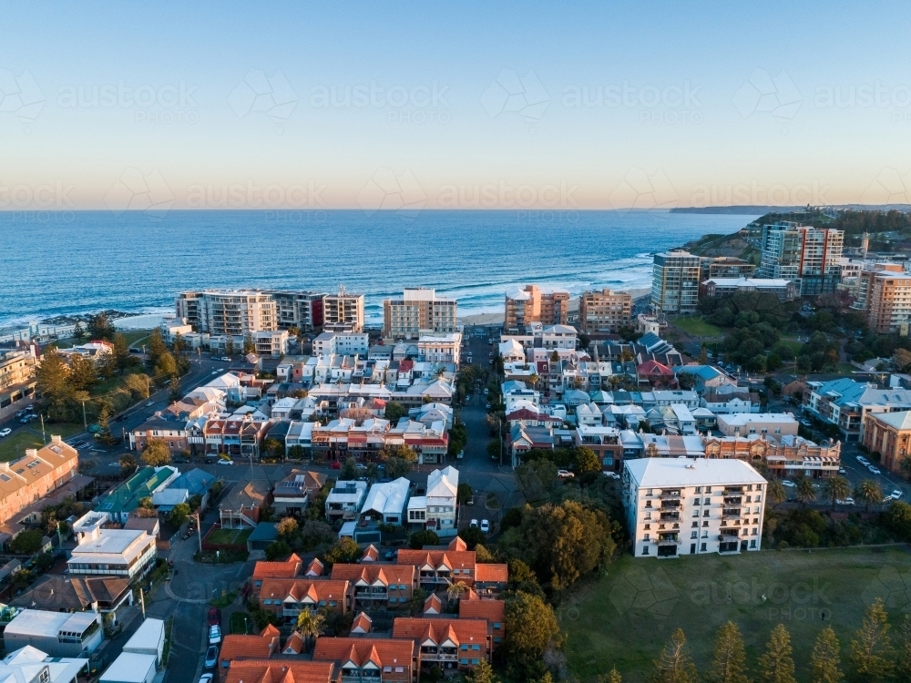 Aerial view of last light on buildings beside the ocean  - Australian Stock Image