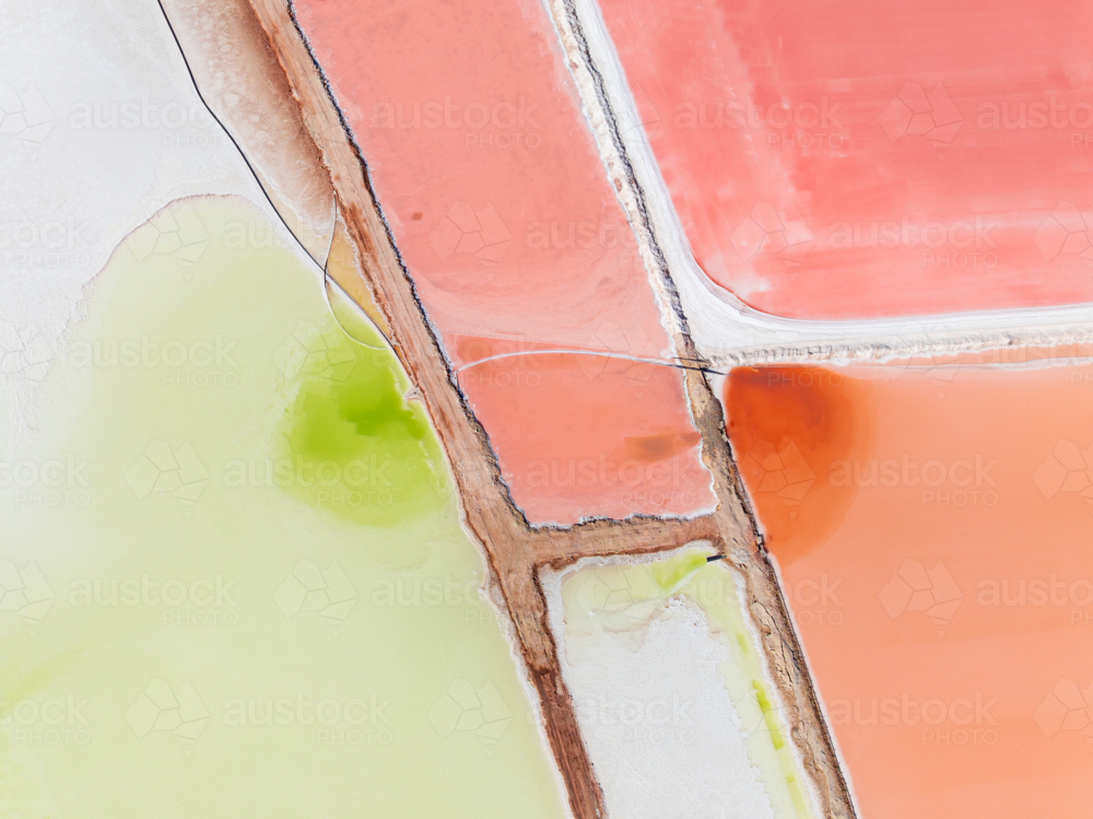 Aerial view of levee banks dividing colourful salt evaporation ponds - Australian Stock Image