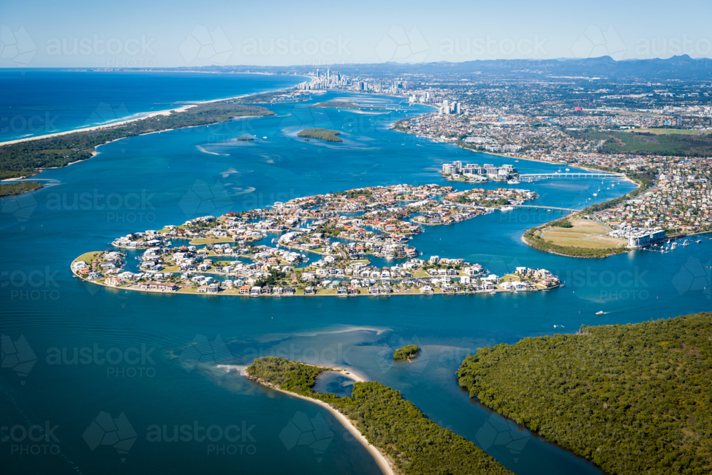 Aerial view of luxury waterfront suburbs and canals stretching toward city skyline - Australian Stock Image