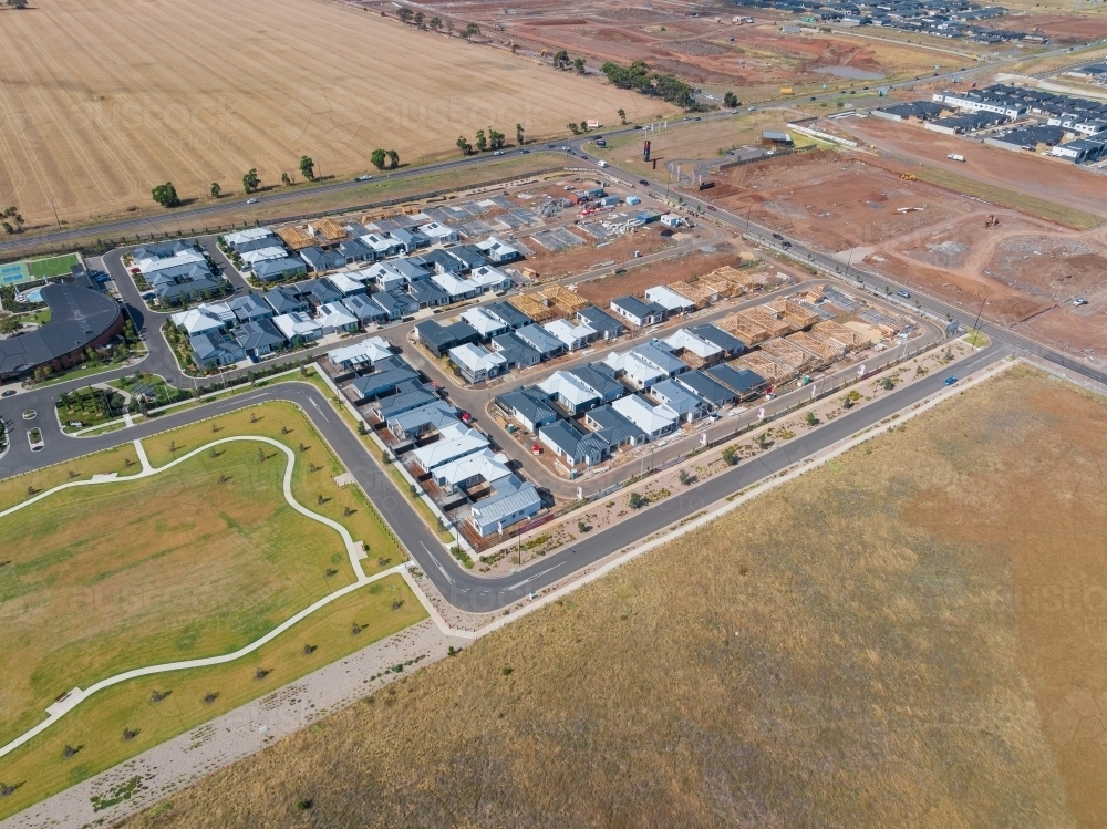 Aerial view of new houses in a subdivision bordering rural land - Australian Stock Image