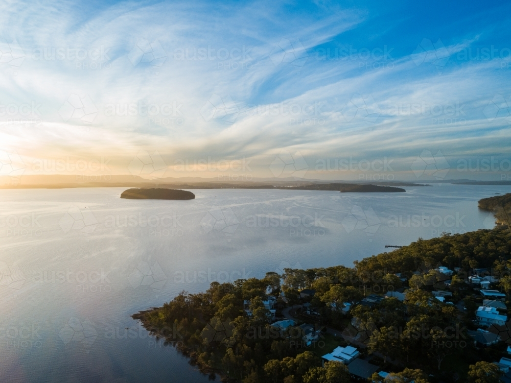 Aerial view of Pulbah Island in blue still water of Lake Macquarie on calm evening - Australian Stock Image