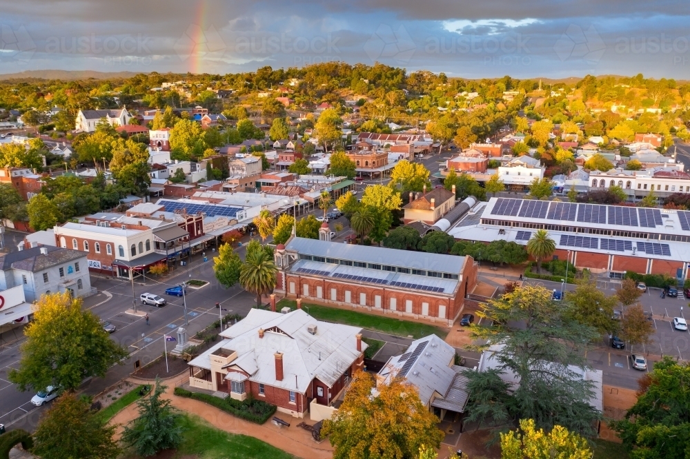 Aerial view of rainbow and cloud formations over a regional town's historic streetscape - Australian Stock Image
