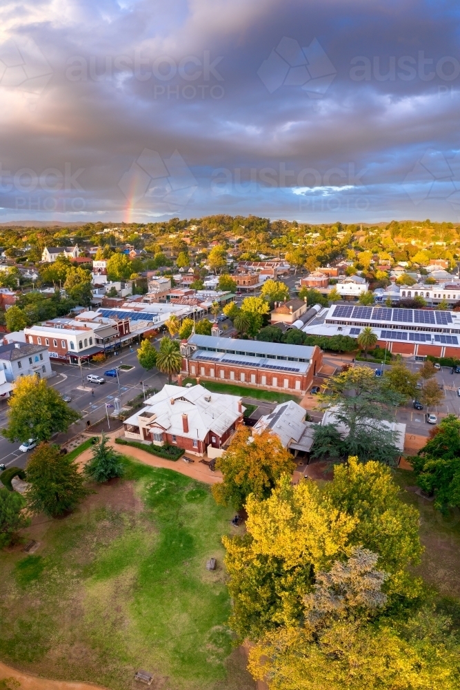 Aerial view of rainbow and cloud formations over a regional town's historic streetscape - Australian Stock Image