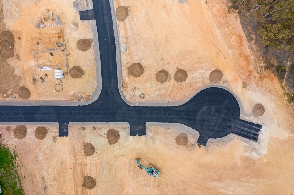 Aerial view of roads and house blocks and machinery in a new housing subdivision - Australian Stock Image