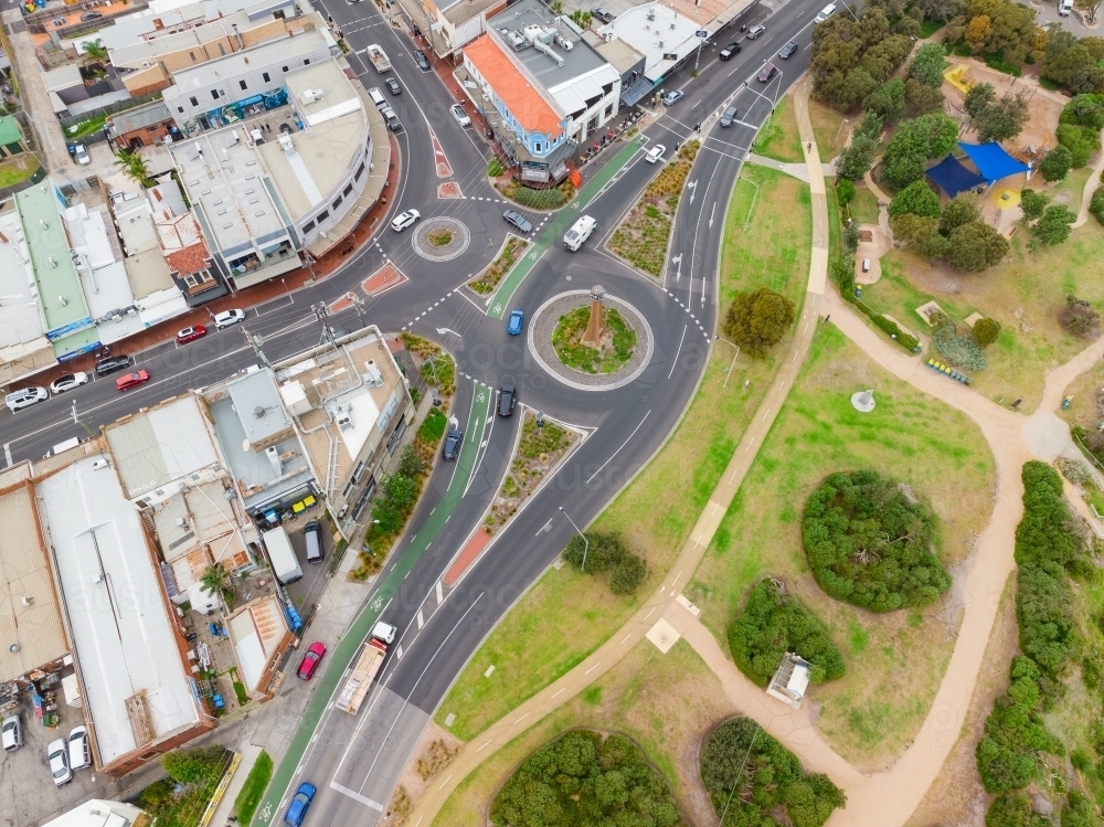 Aerial view of roads and roundabouts running through a shopping strip and parkland - Australian Stock Image