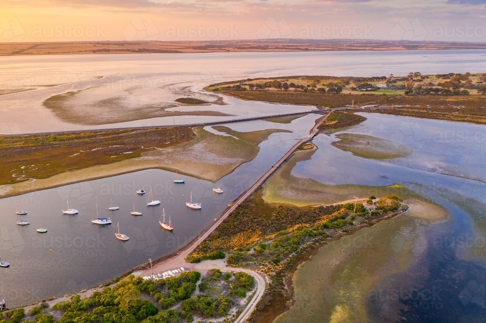 Aerial view of roads joining islands in a coastal bay at sunsets - Australian Stock Image