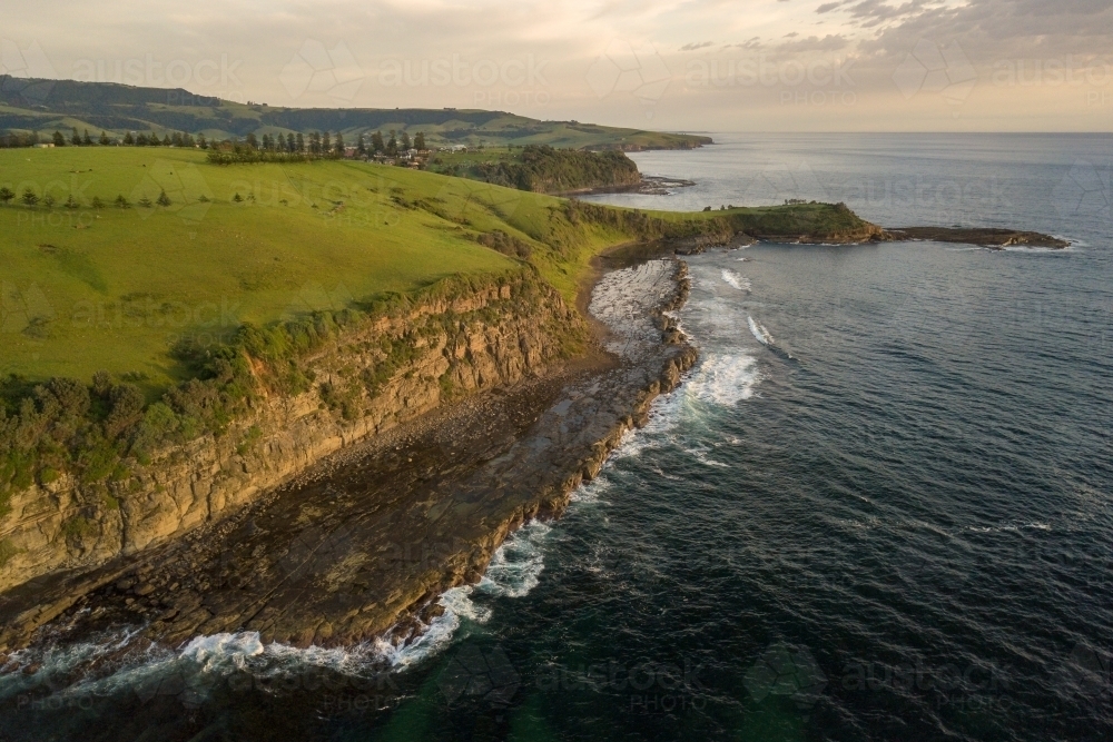 Aerial view of rocky coastline and rolling hills - Australian Stock Image