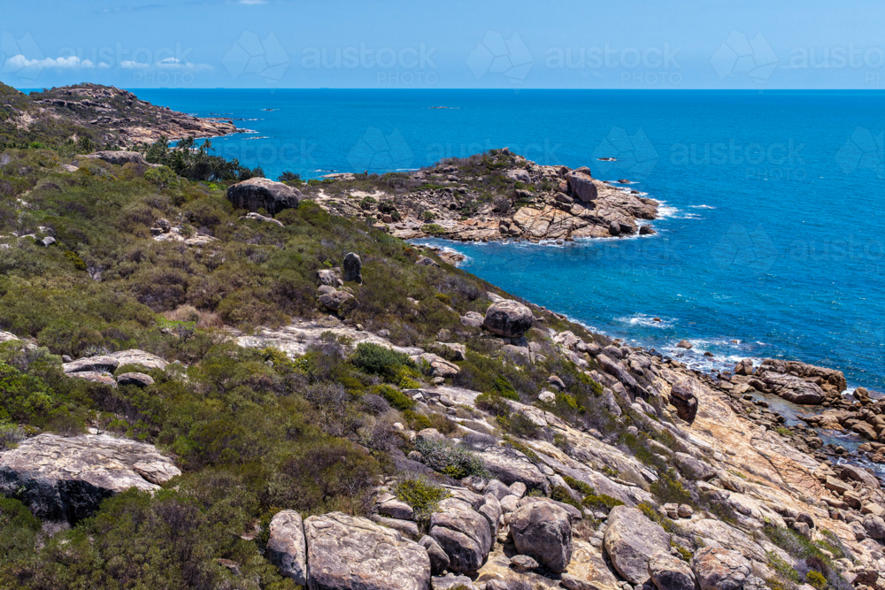 Aerial view of Rose Bay in Bowen, showcasing its shoreline, turquoise waters and rocky headland - Australian Stock Image