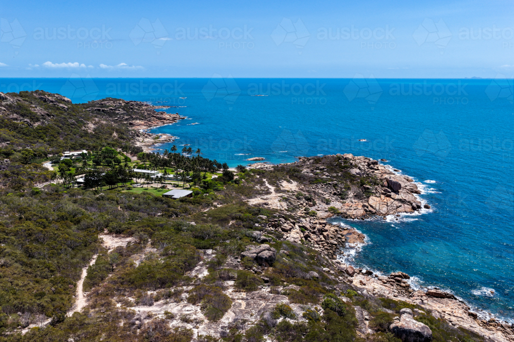 Aerial view of Rose Bay in Bowen, showcasing its shoreline, turquoise waters and rocky headland - Australian Stock Image