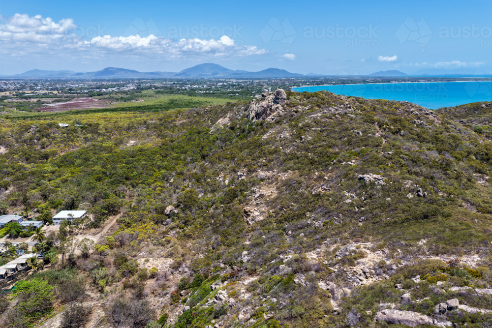 Aerial view of Rose Bay in Bowen, showcasing its shoreline, turquoise waters and rocky landscape - Australian Stock Image